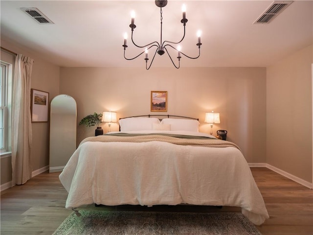 803 Plantation Ridge Overlook, Woodstock, GA 30188 - bedroom with a chandelier, wood finished floors, baseboards, and arched walkways