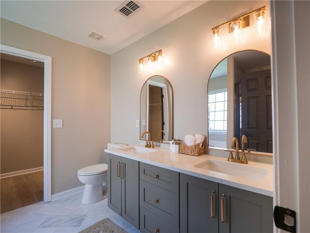 803 Plantation Ridge Overlook, Woodstock, GA 30188 - full bath featuring double vanity, toilet, a walk in closet, and baseboards