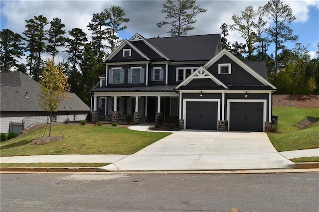 craftsman house featuring a porch, a garage, and a front lawn