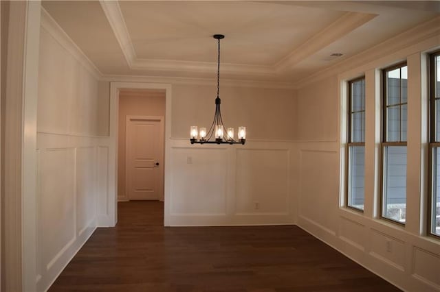 unfurnished dining area featuring dark hardwood / wood-style flooring, an inviting chandelier, a raised ceiling, and a healthy amount of sunlight