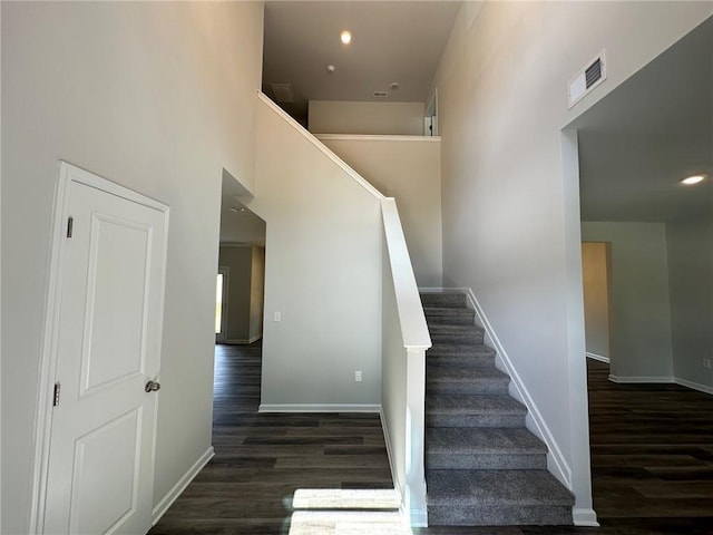 stairway with a high ceiling and hardwood / wood-style floors