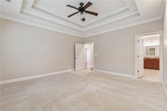 430 La Perla Dr, Sugar Hill, GA 30518 - unfurnished bedroom featuring light carpet, a tray ceiling, crown molding, connected bathroom, and a ceiling fan