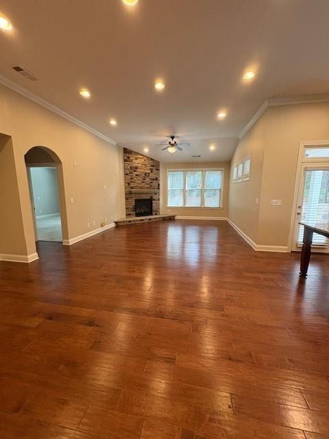 430 La Perla Dr, Sugar Hill, GA 30518 - unfurnished living room featuring a ceiling fan, dark wood finished floors, crown molding, a large fireplace, and arched walkways