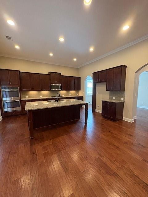 430 La Perla Dr, Sugar Hill, GA 30518 - kitchen featuring arched walkways, stainless steel appliances, ornamental molding, dark brown cabinetry, and dark wood-style flooring