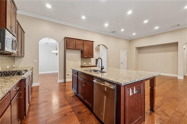 430 La Perla Dr, Sugar Hill, GA 30518 - kitchen with appliances with stainless steel finishes, arched walkways, backsplash, crown molding, and a kitchen island with sink