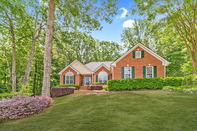 ranch-style home featuring a front yard and brick siding