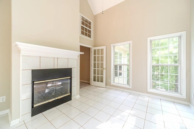 unfurnished living room featuring baseboards, a fireplace, high vaulted ceiling, and light tile patterned floors