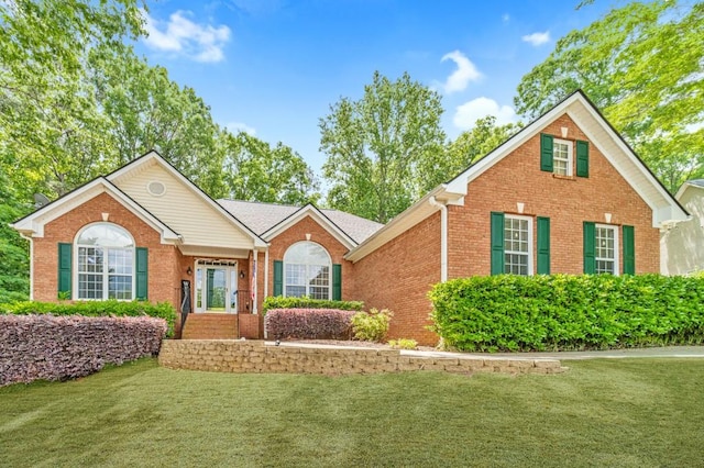 view of front facade with brick siding and a front lawn
