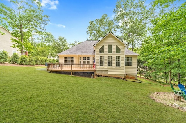 rear view of property featuring a yard, roof with shingles, and a deck