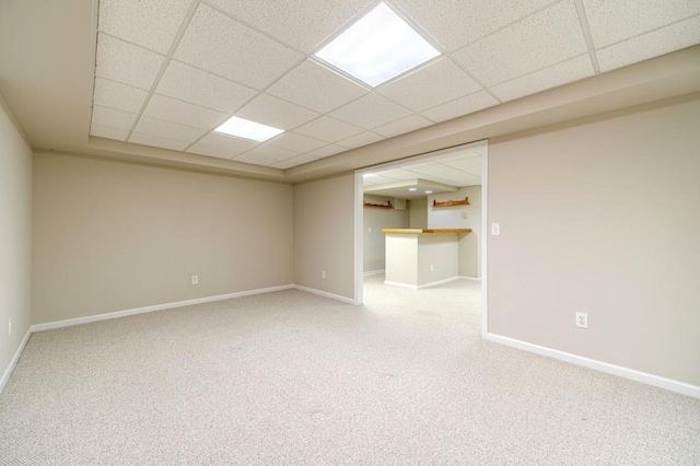 unfurnished room featuring carpet, baseboards, and a paneled ceiling