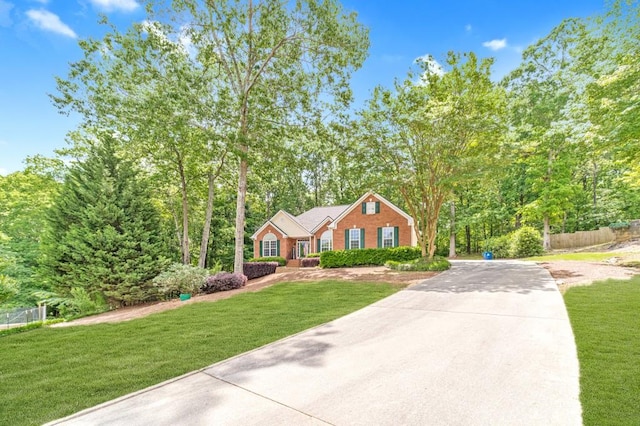 view of front of property featuring a front lawn, concrete driveway, and fence