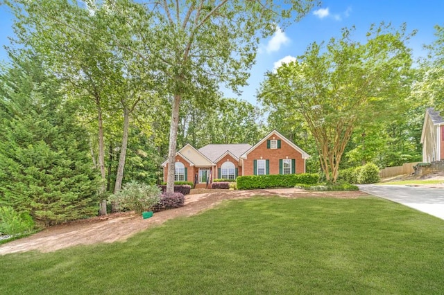 view of front facade with a front lawn, brick siding, and fence
