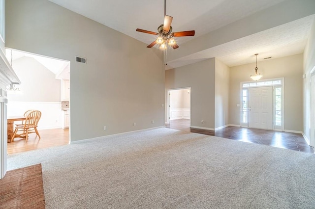 unfurnished living room with visible vents, baseboards, a ceiling fan, and carpet floors