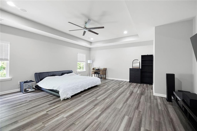 bedroom featuring baseboards, multiple windows, and wood finished floors