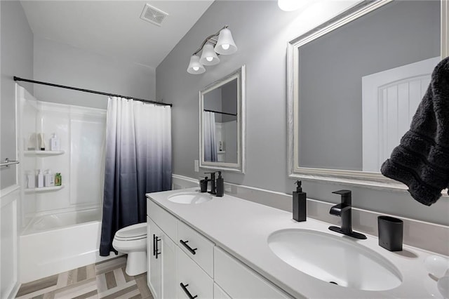 bathroom with double vanity, a sink, shower / bath combo, and toilet