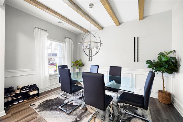 dining area featuring visible vents, a decorative wall, a chandelier, and beamed ceiling