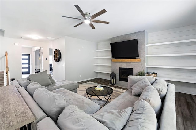 living room featuring baseboards, a ceiling fan, wood finished floors, and a fireplace