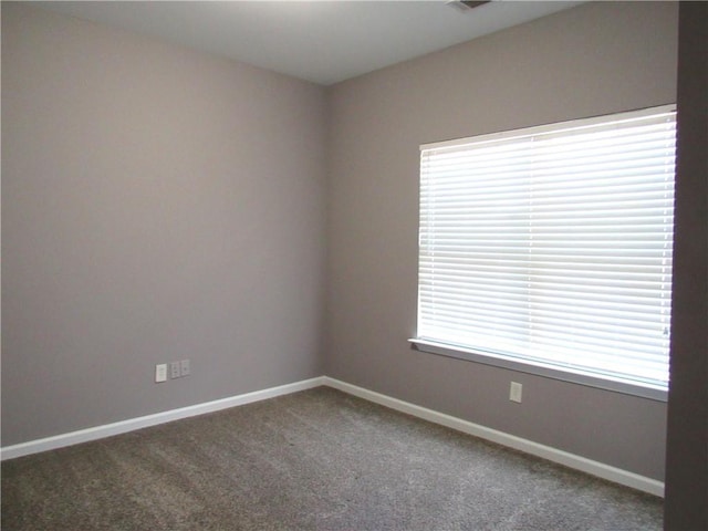 carpeted empty room featuring baseboards