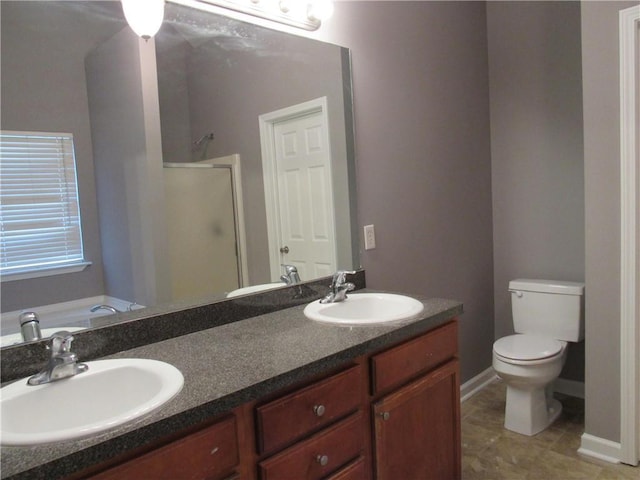 bathroom featuring a stall shower, a sink, toilet, and double vanity