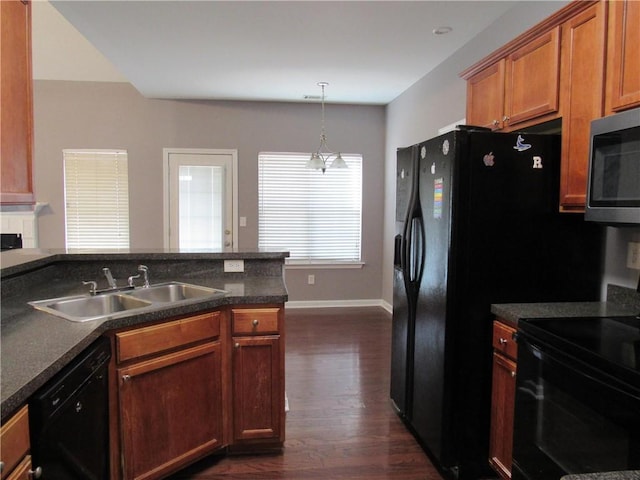 kitchen featuring dishwasher, electric range oven, dark countertops, stainless steel microwave, and a sink