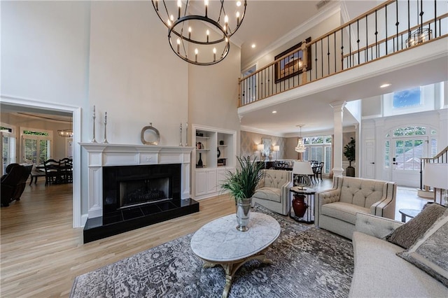 1021 Wetherby Way, Johns Creek, GA 30022 - living area with a high ceiling, a chandelier, ornamental molding, wood finished floors, and a fireplace