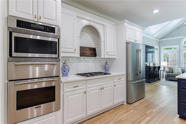 1021 Wetherby Way, Johns Creek, GA 30022 - kitchen with appliances with stainless steel finishes, light countertops, lofted ceiling, white cabinetry, and tasteful backsplash