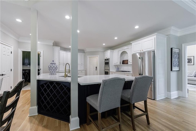 1021 Wetherby Way, Johns Creek, GA 30022 - kitchen with stainless steel appliances, a sink, crown molding, light wood-type flooring, and recessed lighting