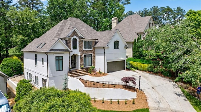 1021 Wetherby Way, Johns Creek, GA 30022 - french country home with driveway, stone siding, stucco siding, a chimney, and a garage