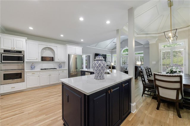 1021 Wetherby Way, Johns Creek, GA 30022 - kitchen with stainless steel appliances, white cabinetry, a spacious island, dark cabinets, and crown molding