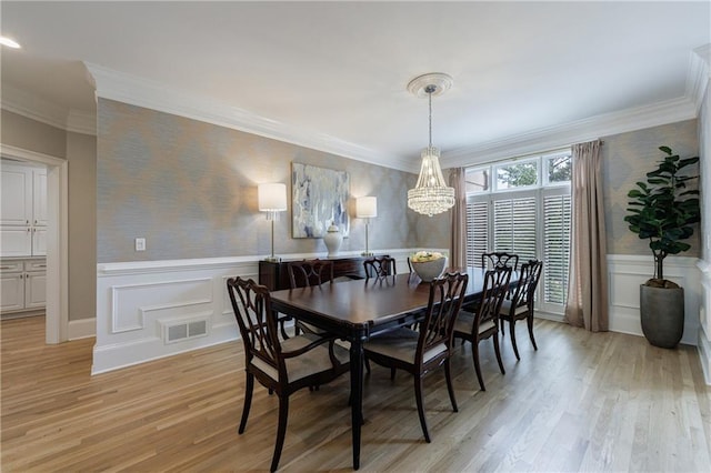 1021 Wetherby Way, Johns Creek, GA 30022 - dining space with a chandelier, light wood-style floors, wallpapered walls, crown molding, and wainscoting