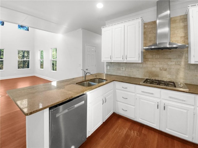 kitchen featuring appliances with stainless steel finishes, white cabinetry, kitchen peninsula, and wall chimney exhaust hood