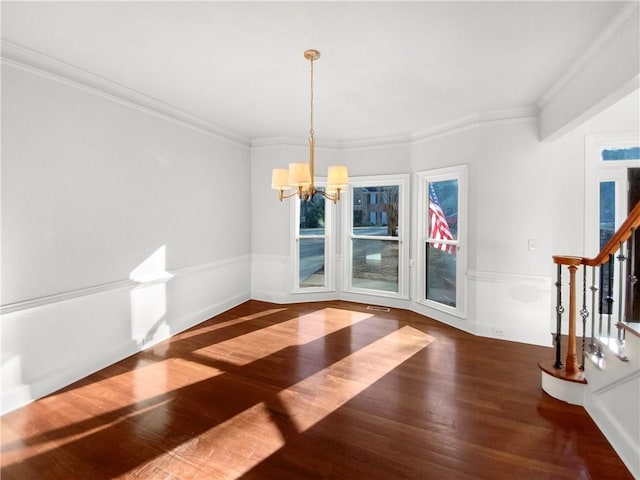 unfurnished dining area with ornamental molding, an inviting chandelier, and dark hardwood / wood-style floors