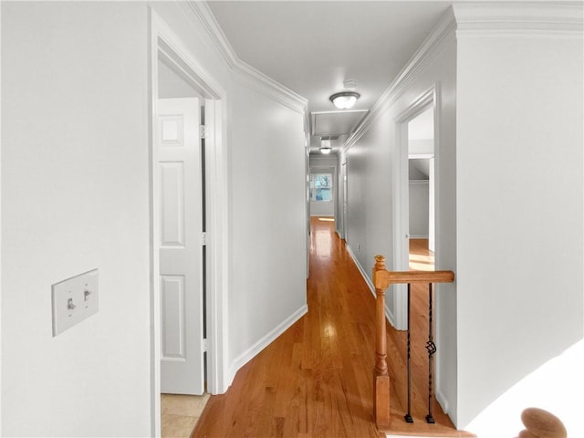 corridor with light wood-type flooring and crown molding