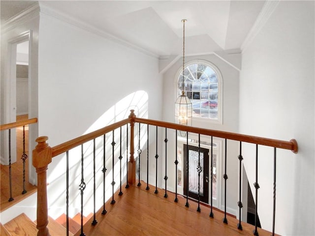 stairs featuring hardwood / wood-style floors, a chandelier, and vaulted ceiling