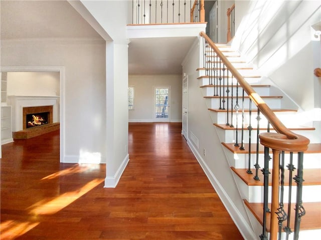 interior space with ornamental molding and dark hardwood / wood-style floors