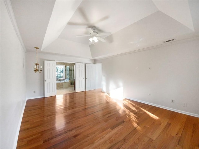 spare room featuring a tray ceiling, crown molding, and dark hardwood / wood-style floors