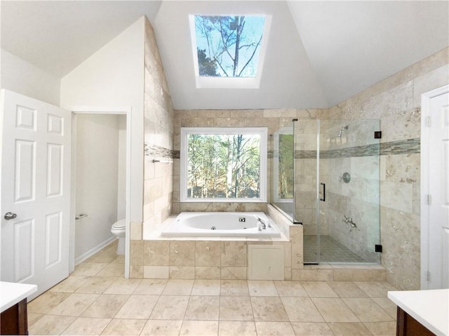 full bathroom with tile patterned flooring, toilet, vaulted ceiling with skylight, separate shower and tub, and vanity