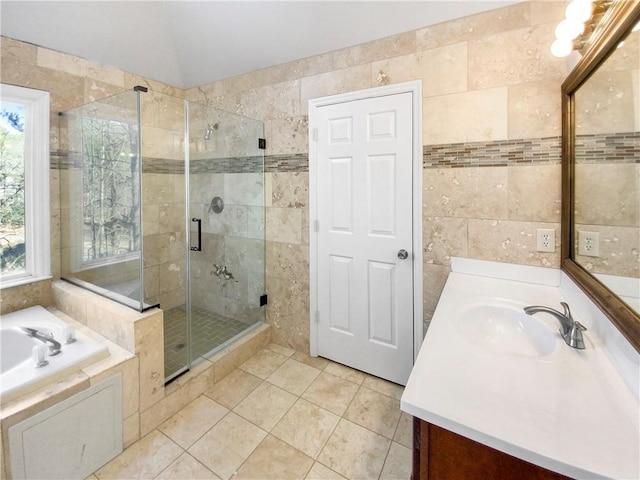 bathroom with vaulted ceiling, tile walls, tile patterned floors, plus walk in shower, and vanity