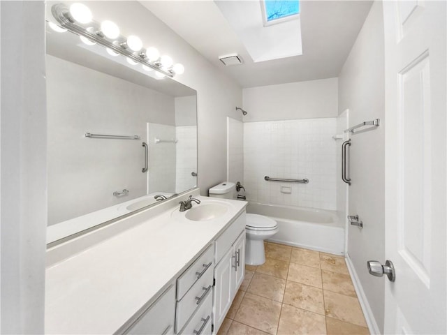 full bathroom with tile patterned flooring, toilet, a skylight, vanity, and tiled shower / bath