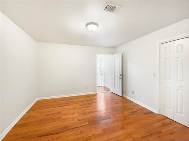 unfurnished room with hardwood / wood-style flooring