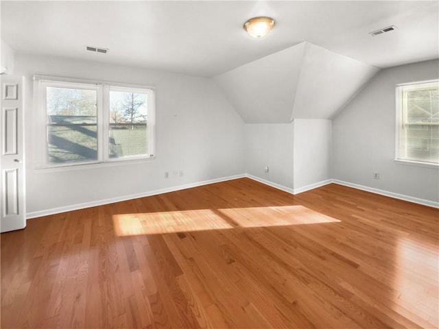 bonus room with hardwood / wood-style floors and vaulted ceiling