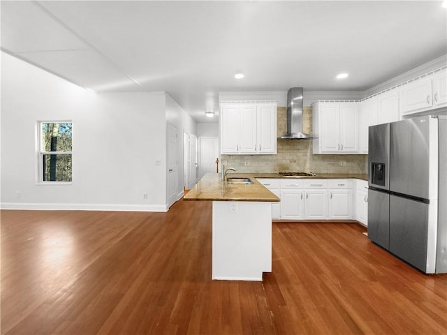 kitchen with white cabinets, appliances with stainless steel finishes, wall chimney exhaust hood, and sink