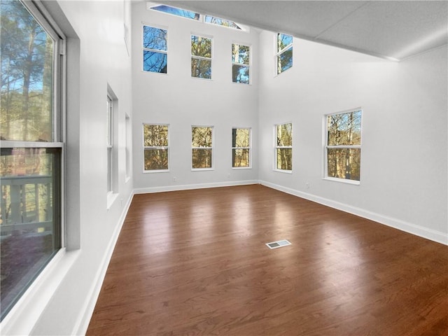 interior space with a high ceiling and dark hardwood / wood-style floors