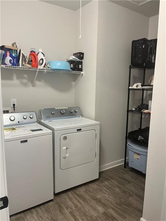 clothes washing area with washer and clothes dryer and dark hardwood / wood-style flooring