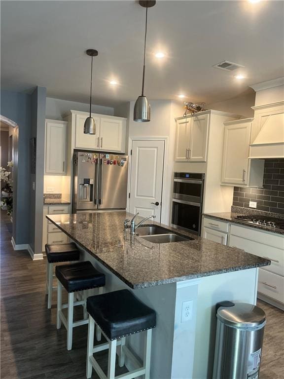 kitchen with pendant lighting, sink, an island with sink, white cabinetry, and stainless steel appliances