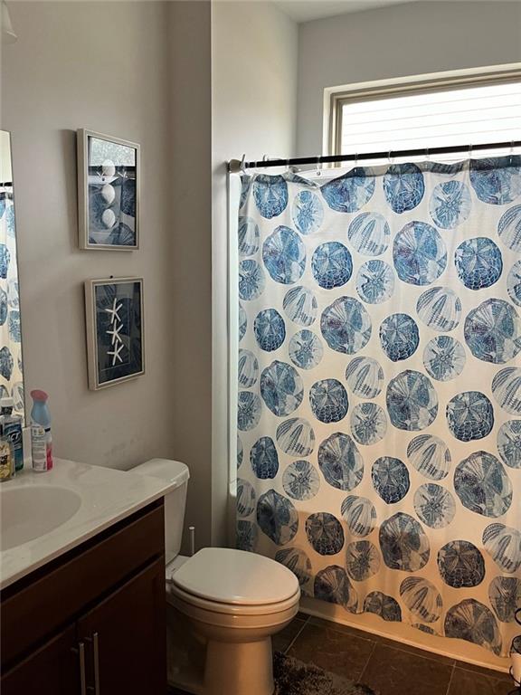 bathroom featuring a shower with curtain, vanity, and toilet