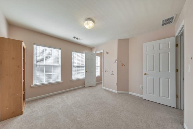 unfurnished bedroom with carpet floors, visible vents, and baseboards