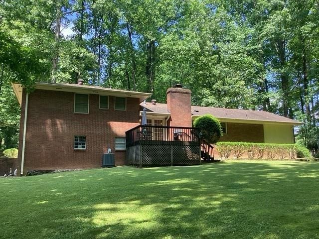 9278 Seminole Rd, Jonesboro, GA 30236 - rear view of property featuring a wooden deck, a lawn, a chimney, and brick siding