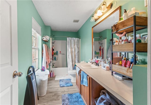 full bathroom featuring shower / bath combo with shower curtain, vanity, wood-type flooring, and toilet