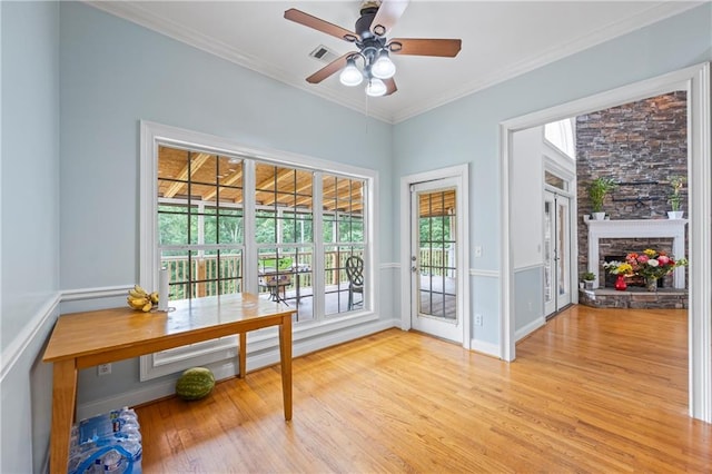 387 Lauren Marie Dr, Braselton, GA 30517 - entryway with light wood-type flooring, ceiling fan, crown molding, and a stone fireplace